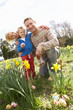 Family On Easter Egg Hunt In Daffodil Field Family On Easter Egg Hunt In Daffodil Field