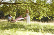 A young couple laying a picnic blanket on the grass
