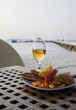A glass of white wine and a plate with snack A glass of white wine and a plate with snack