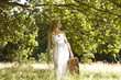 A young woman carrying a picnic basket