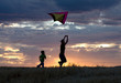Mother and son runs with kite.