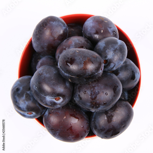 Photo: Plum in a bowl on white background Plum in a bowl on white background