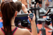 Young woman holding a chronometer and man doing physical exercis