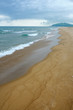 Sand beach view with wavy green sea and cloudy sky Sand beach view with wavy green sea and cloudy sky