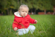 adorable baby sit crouch on green grass near forest  within red
