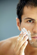 Close-up of young man applying shaving cream