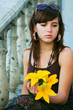 Thoughtful young woman with lily.