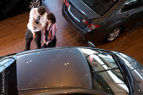 Photo: car salesman explaining car features to customer car salesman explaining car features to customer