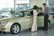 Photo: Young man and woman standing by car and conversing Young man and woman standing by car and conversing