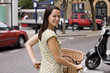 A young woman pushing her bicycle in the street