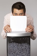 Young caucasian businessman shredding documents