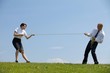 Businessman and businesswoman in a tug of war