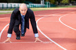 Businessman at the start line of running track