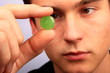Mann mit Halsschmerztablette in der Hand