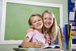 Teacher and young student in class writing