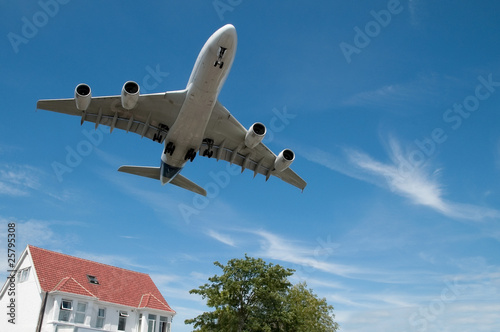 Photo: large jet aircraft on landing over suburban housing large jet aircraft on landing over suburban housing
