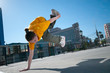 Teenage hip-hop girl dancing over city landscape