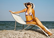 The girl in a hat having a rest on seacoast The girl in a hat having a rest on seacoast