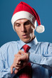 Photo: young man in red christmas hat look at his hand's clock young man in red christmas hat look at his hand's clock