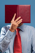 Photo: man with red open book in front of his head man with red open book in front of his head
