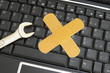 pc keyboard and wrench with bandage - computer repair