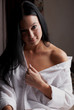 Young brunette woman in her bedroom