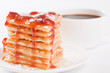 Pile of waffles with honey, strawberry jam and powdered sugar an