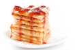 Pile of waffles with honey, strawberry jam and powdered sugar