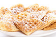 Stack of waffles in shape of heart with powdered sugar