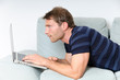 Young man relaxing with laptop on a couch