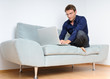 Young man relaxing with laptop on a couch