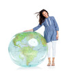 Beautiful young girl standing by a globe on white