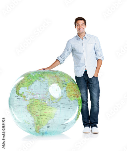 Photo: Handsome young boy standing by a globe on white Handsome young boy standing by a globe on white