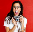 Excited young woman shouting holding a camera Excited young woman shouting holding a camera