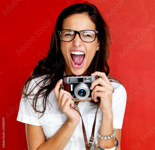 Photo: Excited young woman shouting holding a camera Excited young woman shouting holding a camera