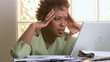 Portrait of concerned woman with laptop and bills Portrait of concerned woman with laptop and bills