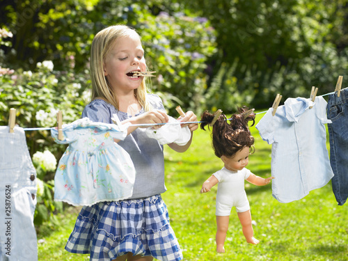 girl spreading out her doll clothes