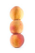 Three fresh peaches stacked on a white isolated background