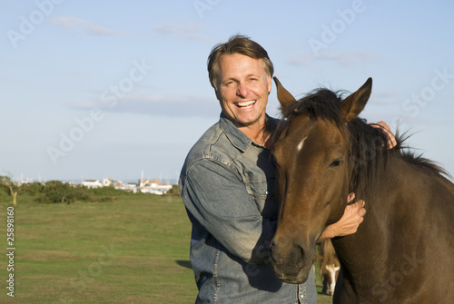 Photo: happy man petting his horse happy man petting his horse
