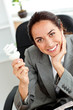 Beautiful businesswoman holding a light bulb in her hand sitting