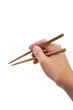 Hand holding a pair of chopsticks
