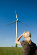 Female engineer looks at wind turbine - alternative and green en