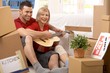 Couple playing guitar together in new house