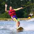 Älterer Mann auf Wakeboard winkt