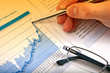 Business man's hand showing diagram on financial report with pen