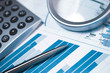 Profit bar chart, calculator and pen.
