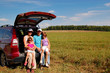 Family near their car on vacation