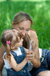 Mother and daughter in jeans with dandelion outdoor