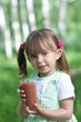 Little girl portrait with glass plum or cherry juice outdoor