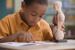 African boy studying anatomy in classroom